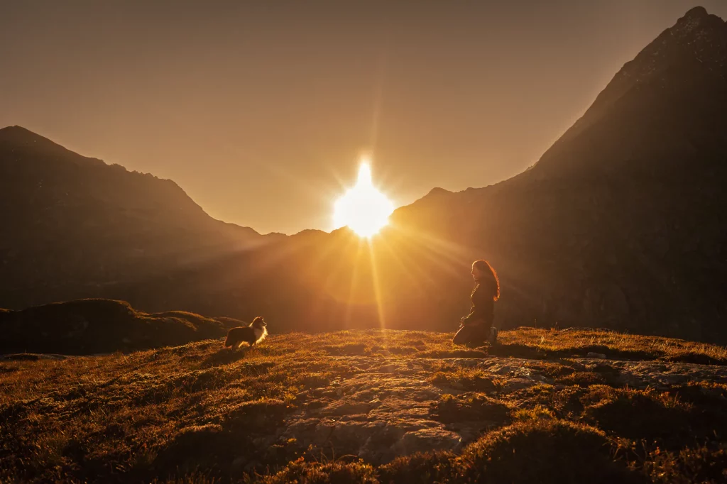 Einzigartiges Erlebnis bei Sonnenaufgang in den schweizer Bergen bei Fotoshooting mit Mensch und Hund
