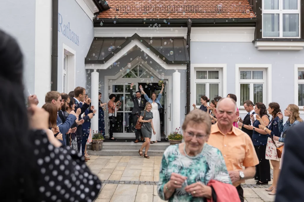Freudiger Moment wie das Brautpaar nach der Hochzeit aus dem Standesamt kommt
