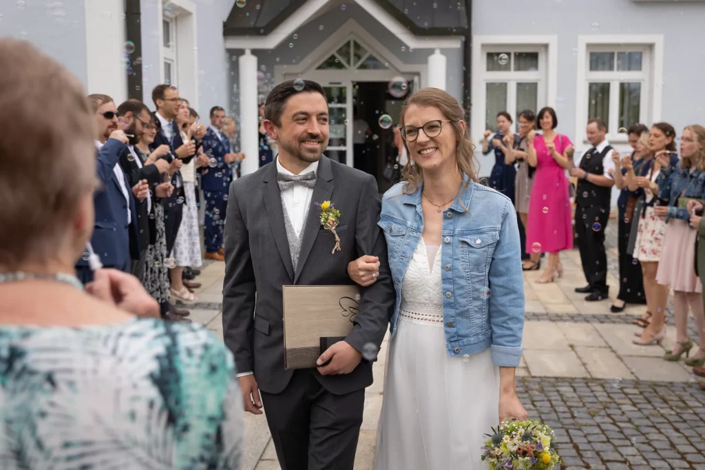 Brautpaar kommt überglücklich aus dem Standesamt nach der Heirat