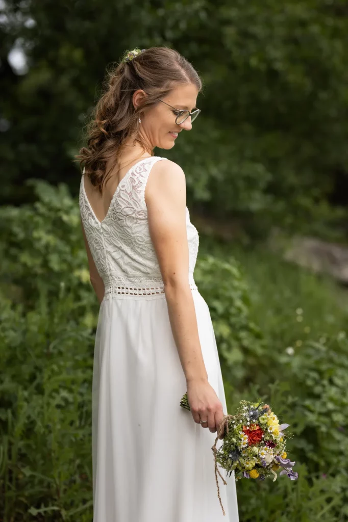 Braut im Hochzeitskleid mit Brautstrauß, Foto in der Natur