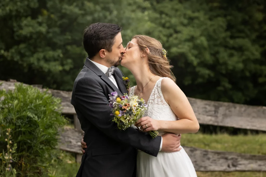 Brautpaar gibt sich eine Kuss, freie Natur, traumhafter Garten
