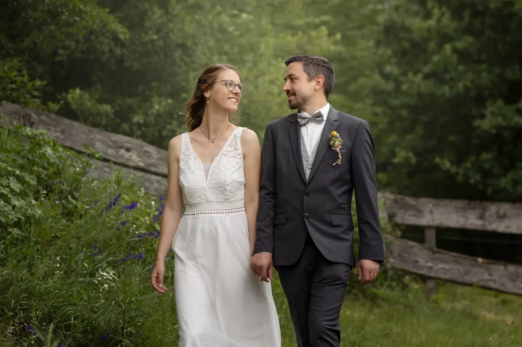 Liebevolles Bild von Brautpaar, lachend ansehend gehen durch wunderschönen Garten