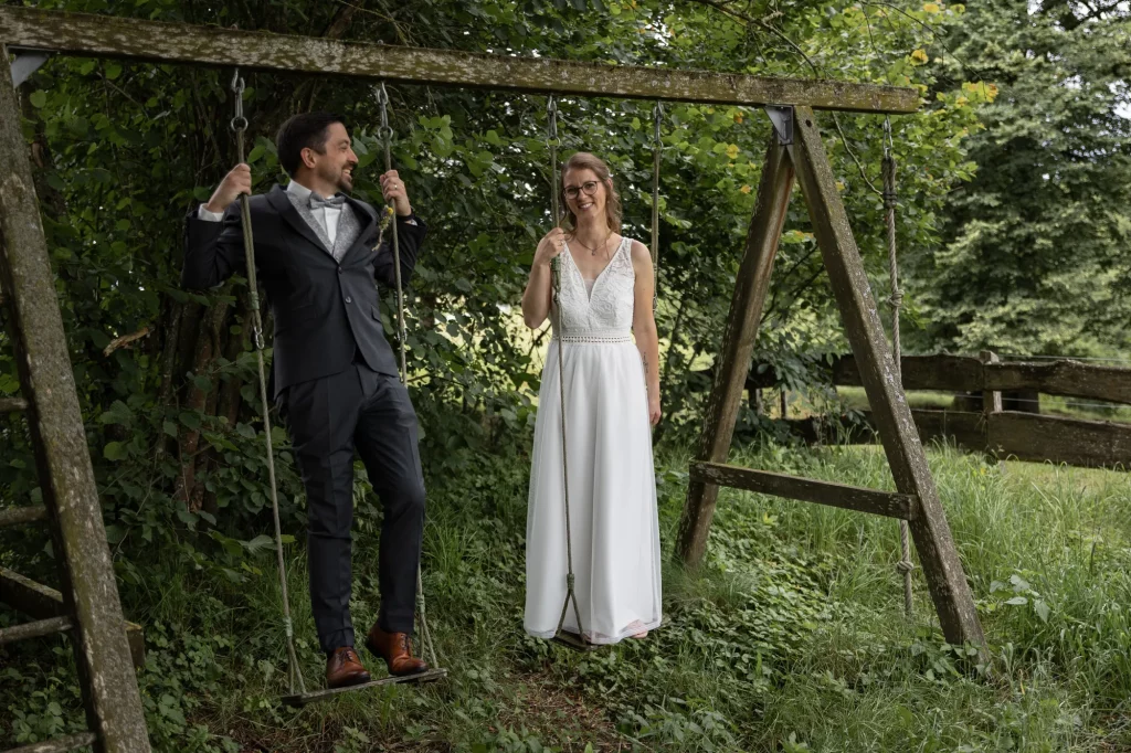 Brautpaar genießt den Moment im freien auf Schaukel