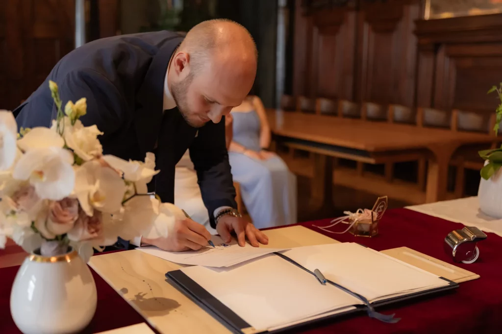 Hochzeit, Bräutigam unterschreibt im Standesamt von Passau, Hochzeitsfotografie