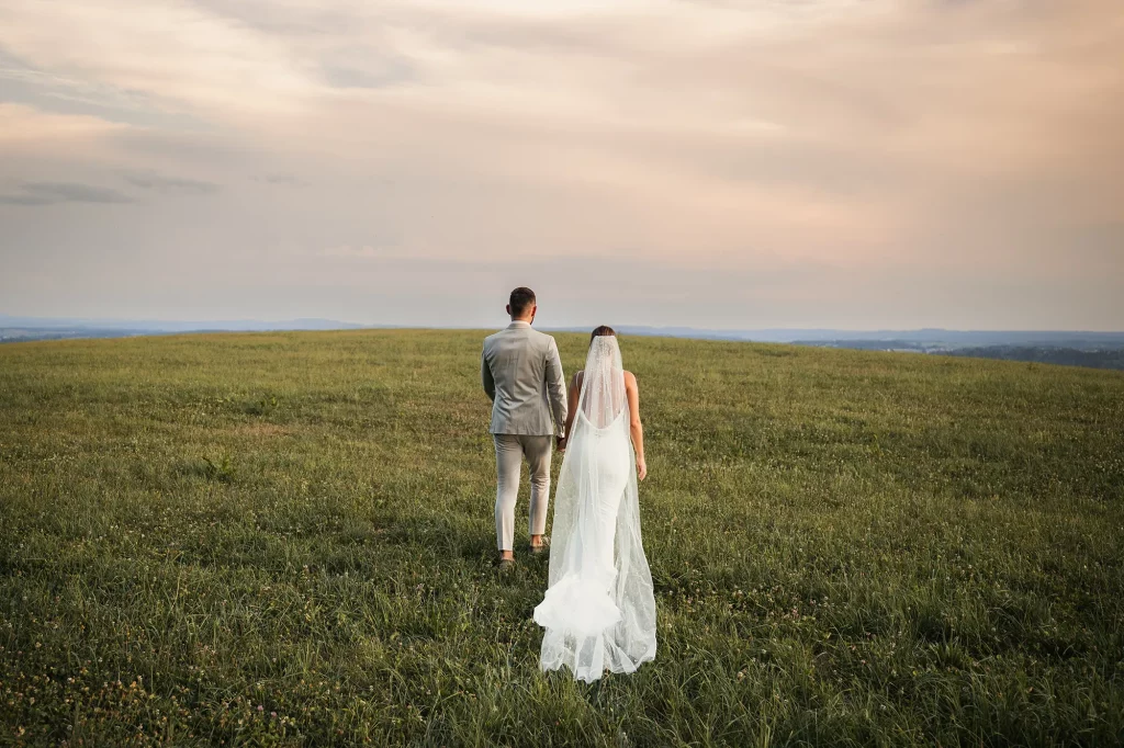 Wunderschönes Bild von Brautpaar gehend im Sonnenuntergang, Neukrichen vorm Wald