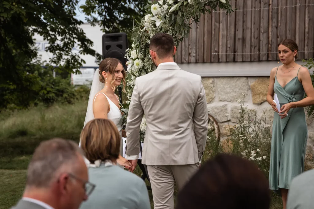 Brautpaar wirft sich liebevollen Blick bei freier Trauung zu, Heiraten am Landgasthaus Müller in Ruderting