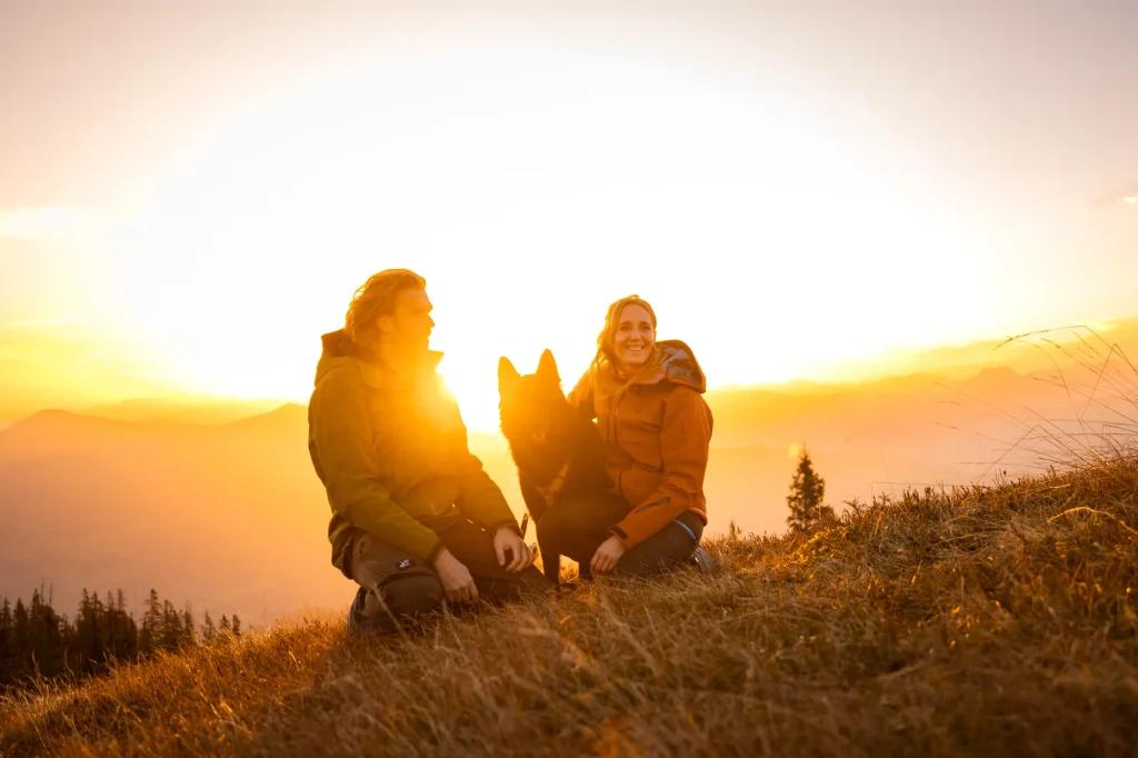 Wunderbarer Sonnenaufgang in den Bergen mit Fotoshooting von Hund und Mensch