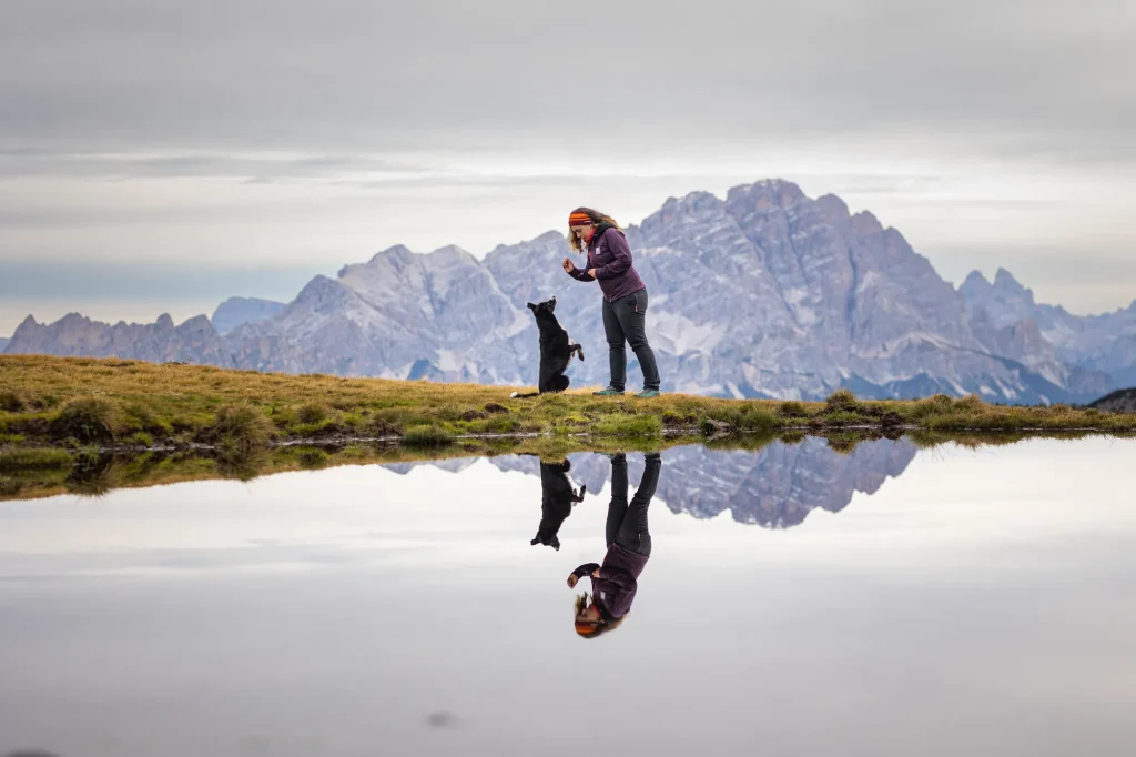 Professionelles Fotoshooting zum Sonnenaufgang am Passo di Giau mit Mensch und Hund vor Spiegelsee