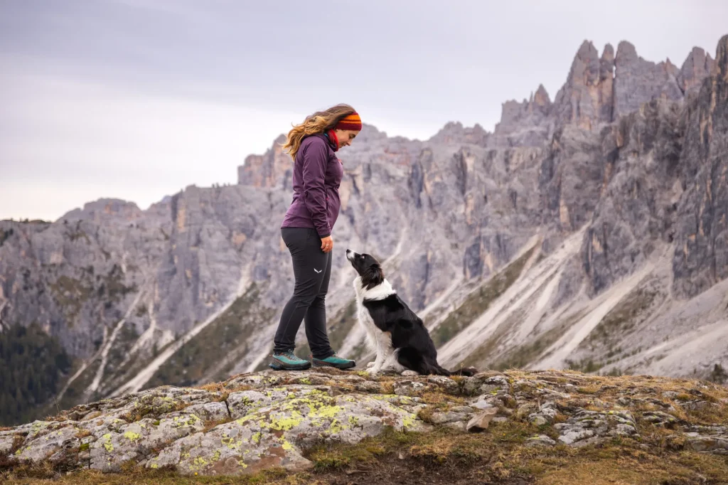 Wundervolles Bild von Mensch mit Hund vor überragender Bergkulisse am Passo Giau