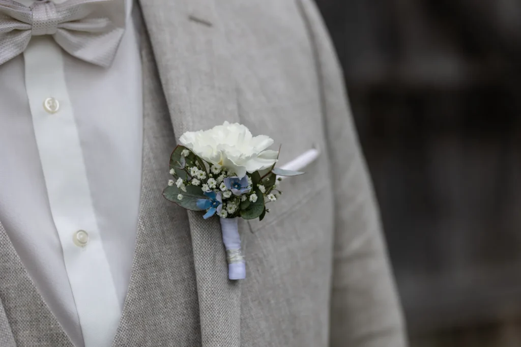 Wunderschönes Detailbild von Hochzeitsanzug mit Blumenschmuck. Heiraten in Neukirchen vorm Wald, mit Daniela Schmid Hochzeitsfotografin