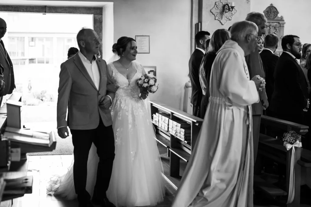 Schönes schwarz-weiß Bild von Braut bei Einzug in die Pfarrkirche. Heiraten im Landkreis Passau