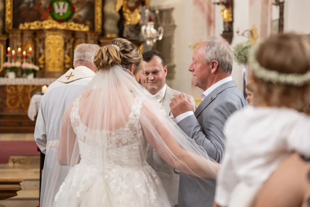 Braut und Bräutigam sehen sich einander tief in die Augen bei kirchlicher Hochzeit in Neukirchen vorm Wald