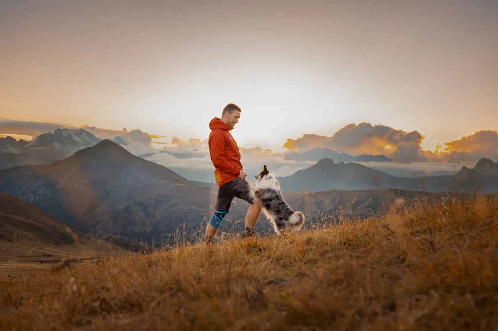 Sehr schönes Bild von Mensch und Hund im Wanderurlaub bei Fotowanderung durch die Dolomiten am Passo Giau