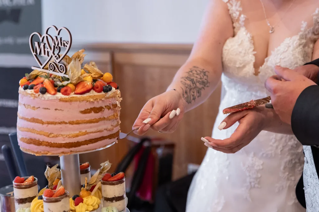 Das Brautpaar macht den Kuchenanschnitt. Sehr schönes Detailbild bei Hochzeitsfeier im Gasthaus zur Post in Neukirchen vorm Wald