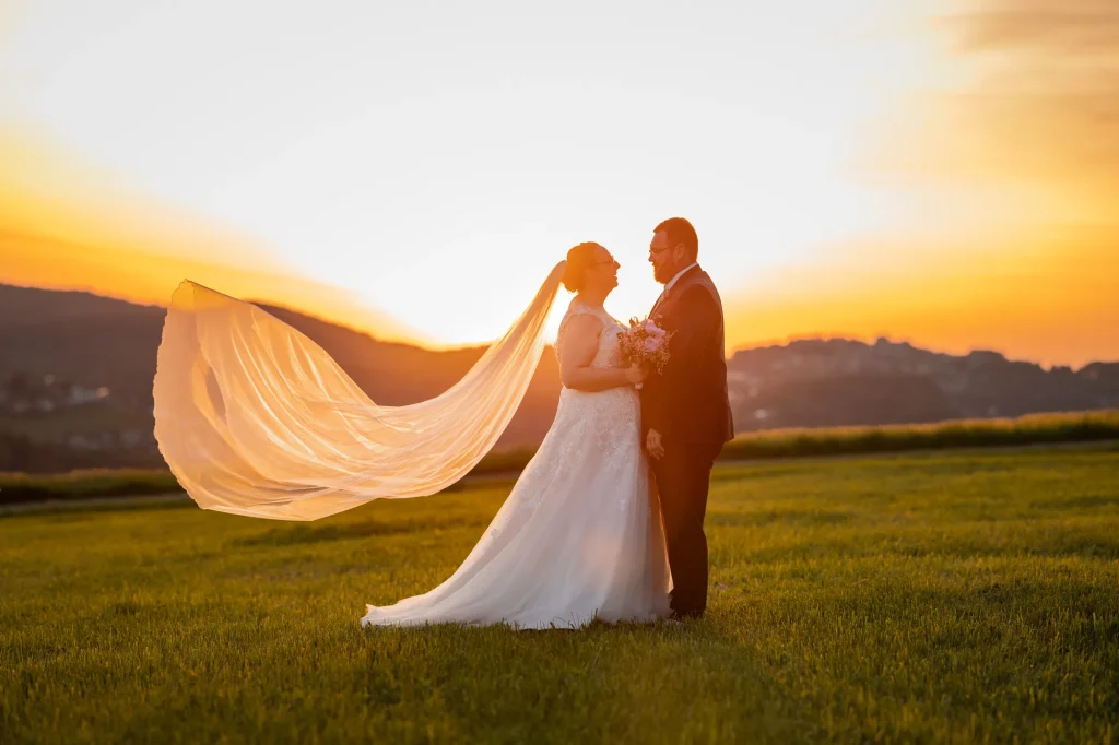 Dieses Bild zeigt ein Brautpaar im goldenen Abendlicht bei Fotoshooting. Hochzeitsbilder in der Natur von Daniela Schmid Fotografie