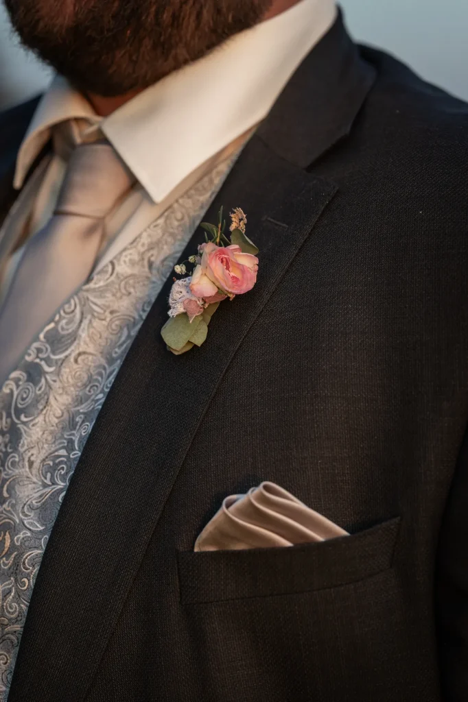 Eine Hochzeit mit wunderschönen liebevollen Detailbilder von dieser Ansteckblume an Hochzeitsanzug. Heiraten in Passau, Oberösterreich und Bayern