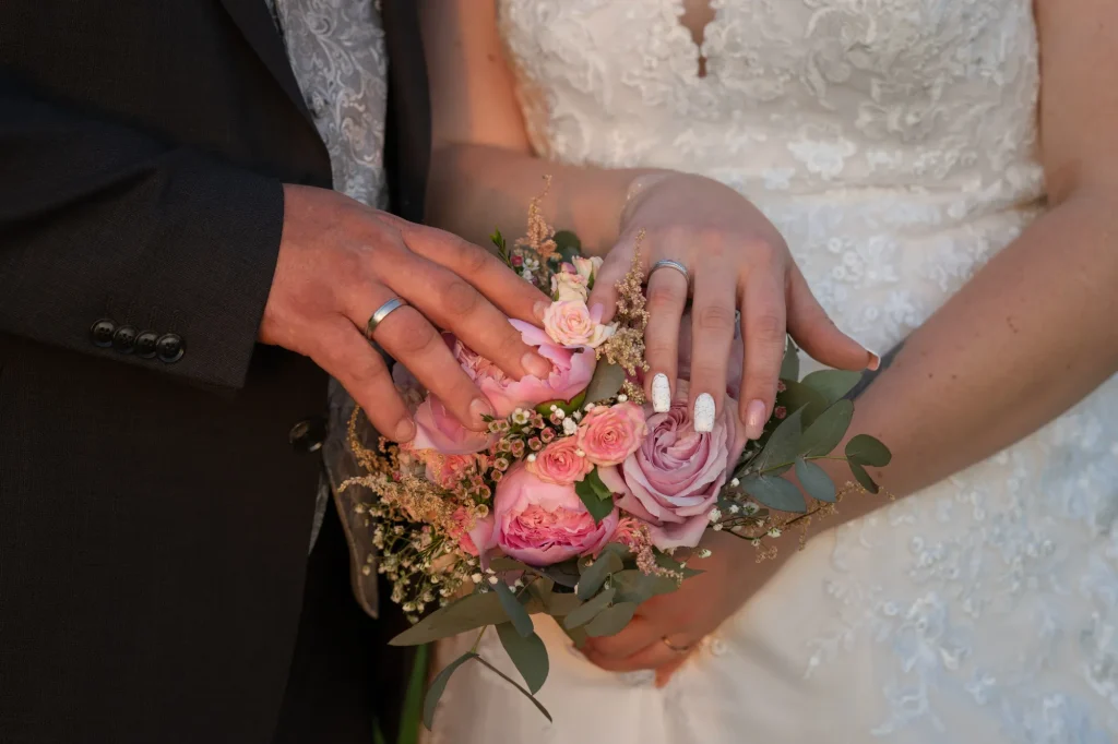 Ein schönes Bild von professioneller Hochzeitsfotografie, Detailbilder von Blumenstrauß mit Händen und Ringe, von Daniela Schmid Fotografie