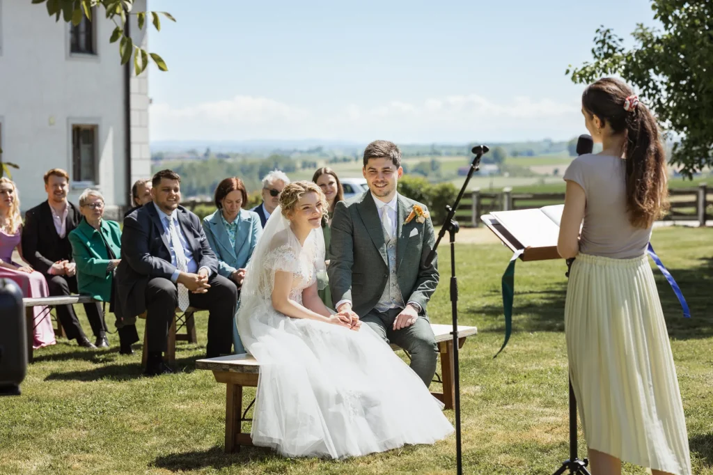Während der rührenden Worte der Traurednerin lauschen alle gespannt den tollen Geschichten zu. Freie Trauung bei perfekten Wetter, professionell fotografiert von Daniela Schmid Fotografie