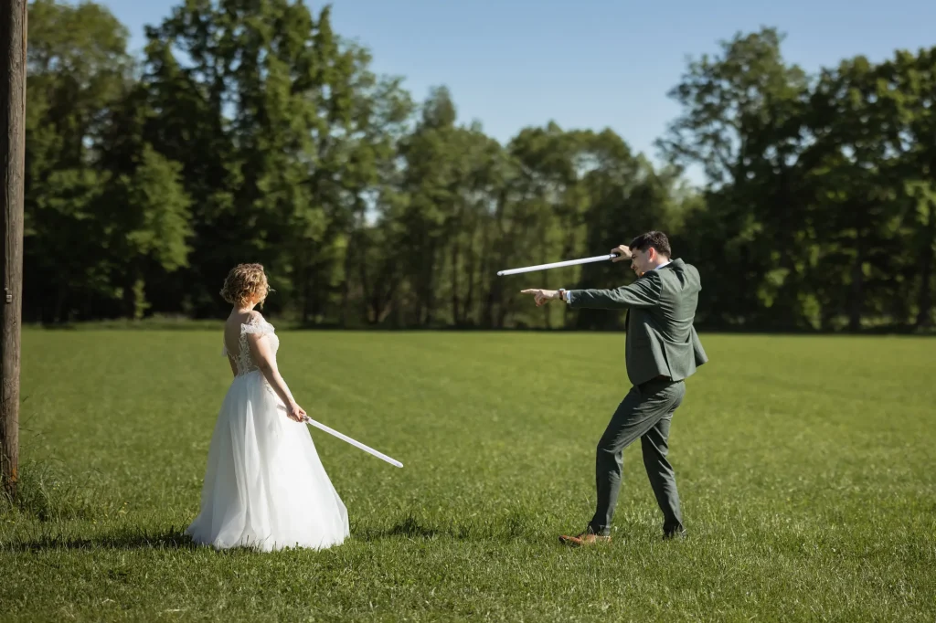 Dieses Bild zeigt das Brautpaar bei der letzten Probe für den Lichtschwertkampf als Höhepunkt des Hochzeitstanzs. Hochzeitsreportagen von Daniela Schmid Fotografie aus Bezirk Schärding, Niederbayern und Umgebung