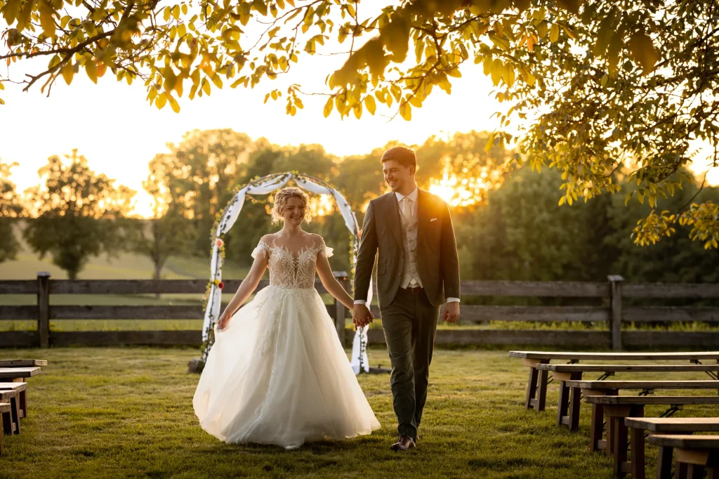 Dieses natürliche ungestellte Bild zeigt das frisch verheiratete Brautpaar bei traumhaften Sonnenuntergang am Rahaberghof im Bezirk Schärding. Fotografiert von Daniela Schmid Fotografie