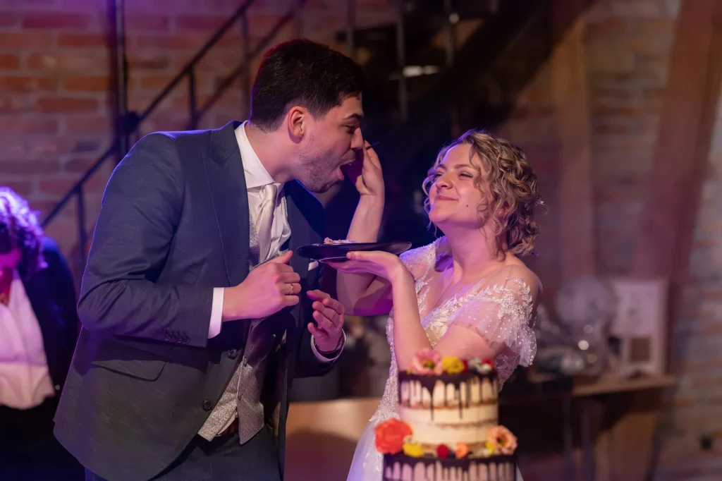 Dieses wunderschöne Bild vom glücklichen Brautpaar beim Anschnitt der Hochzeitstorte. Daniela Schmid Fotografie begleitet euch fotografisch bei eurer Traumhochzeit und schafft unvergessliche Erinnerungen.