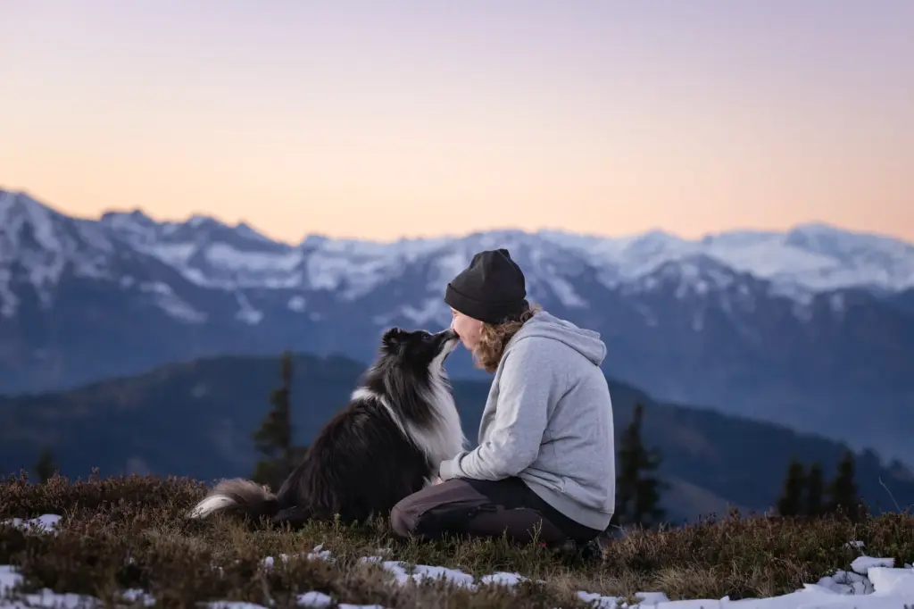 Sehr innige Beziehung zwischen Mensch und Hund bei Sonnenaufgang am Hochkönig
